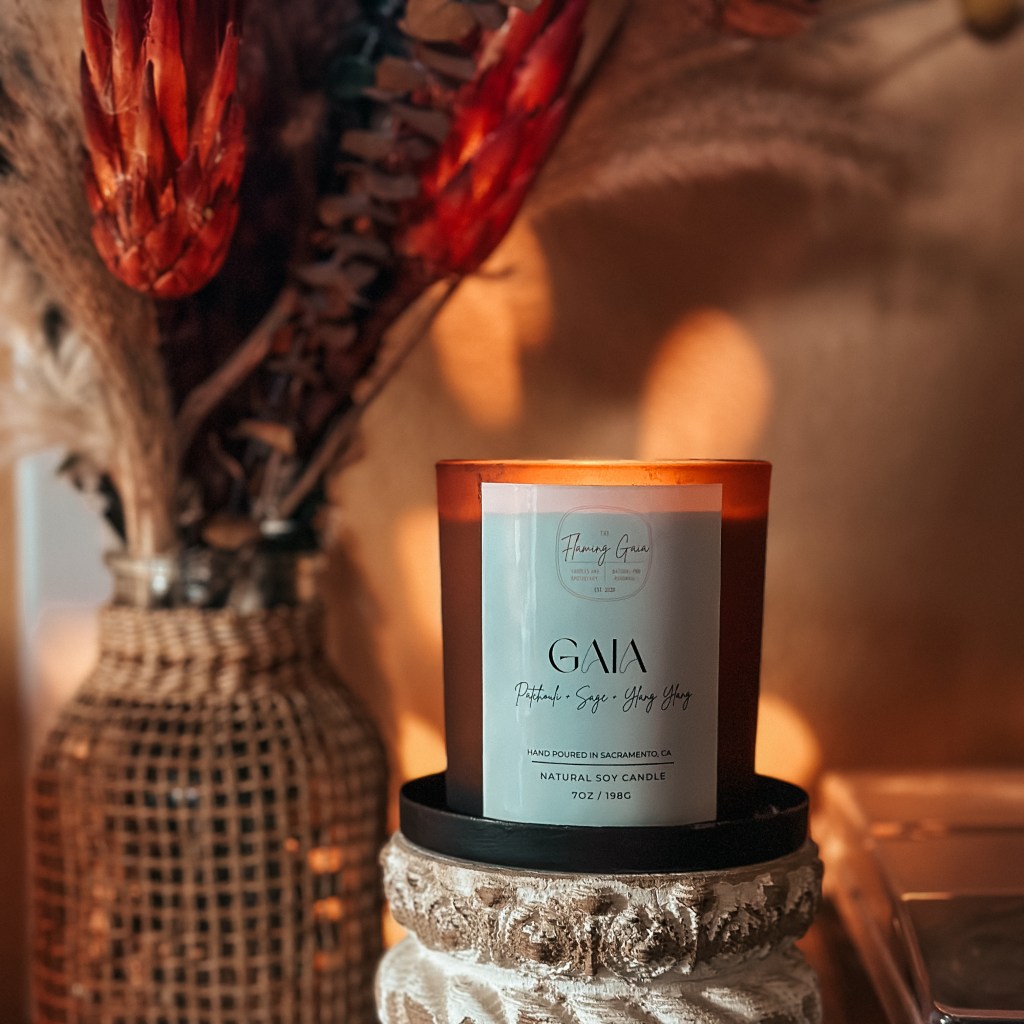 A candle sitting on a table next to a vase of flowers.