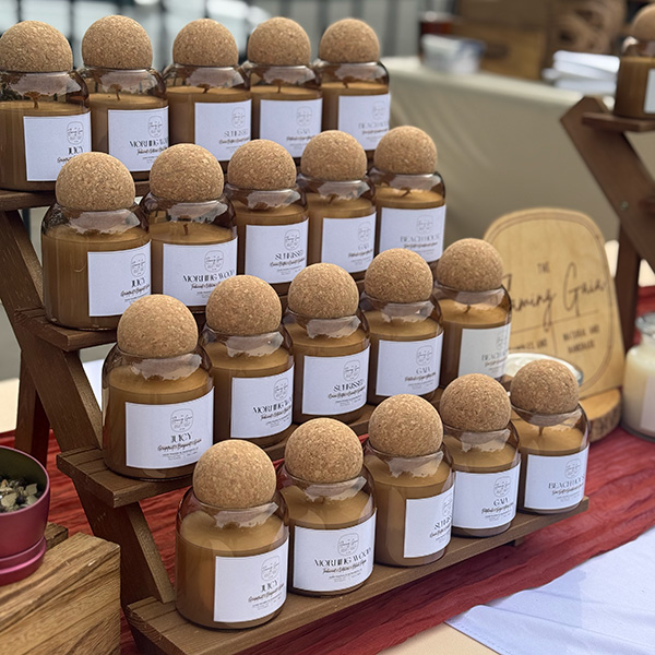 4 tiered wood stand with glass domed candle vessels with sphere cork lids.